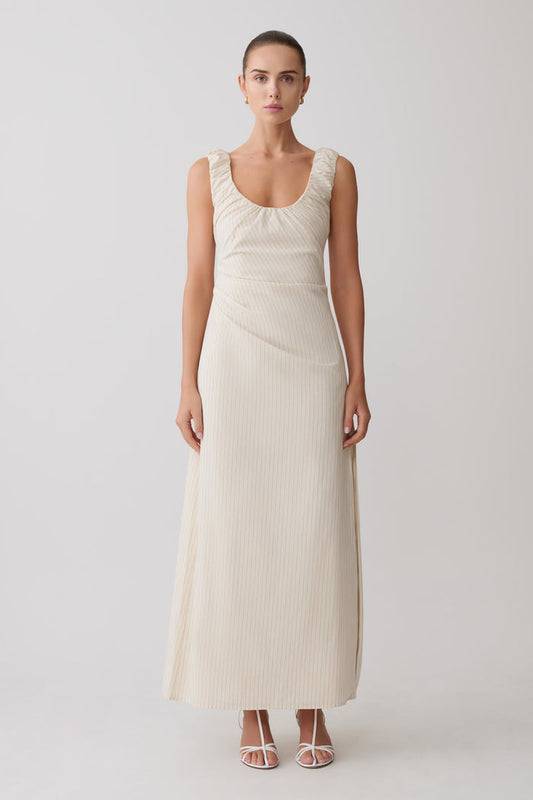 Woman wearing a cream-coloured striped maxi dress.