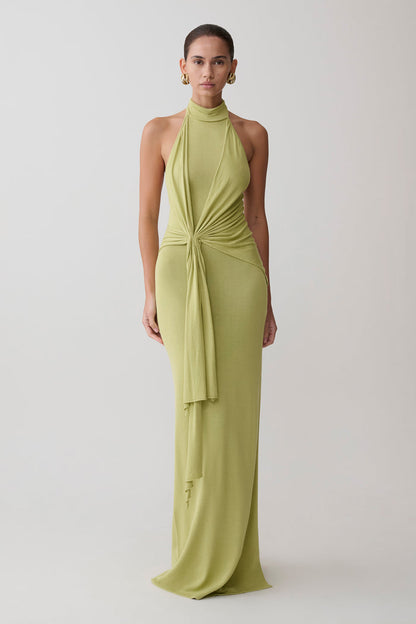 Woman wearing a green halter neck dress.
