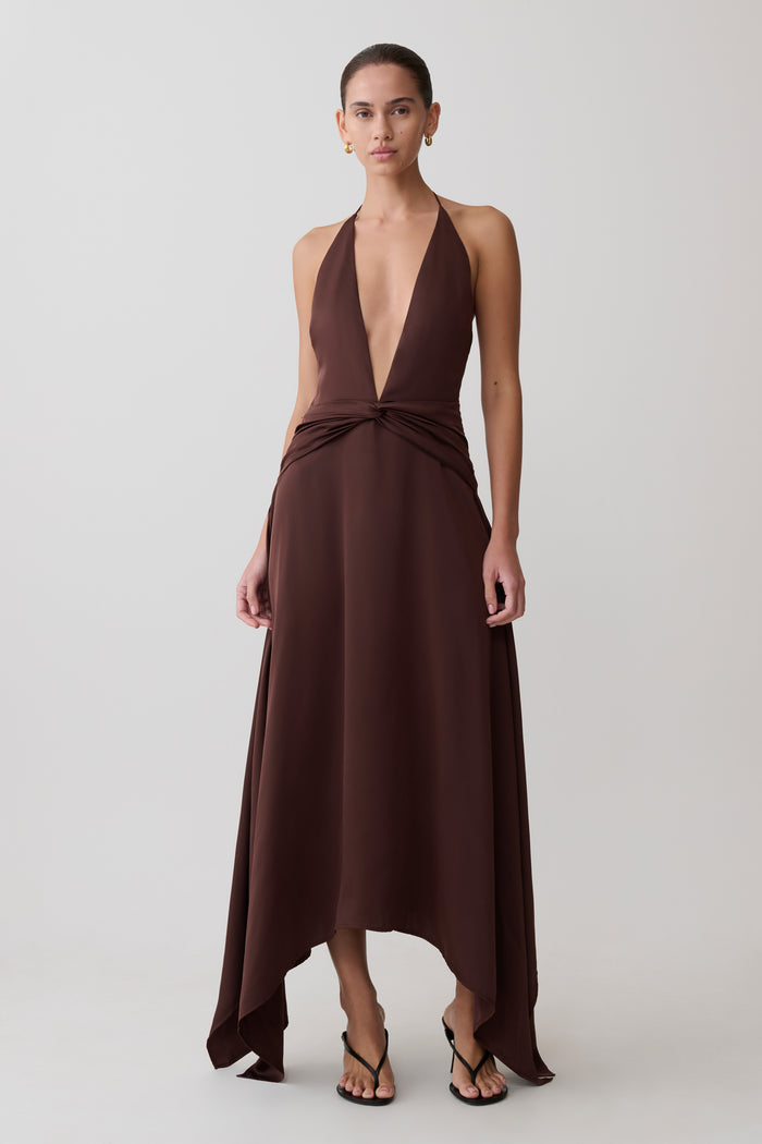 Woman wearing a brown halter neck dress on a white background