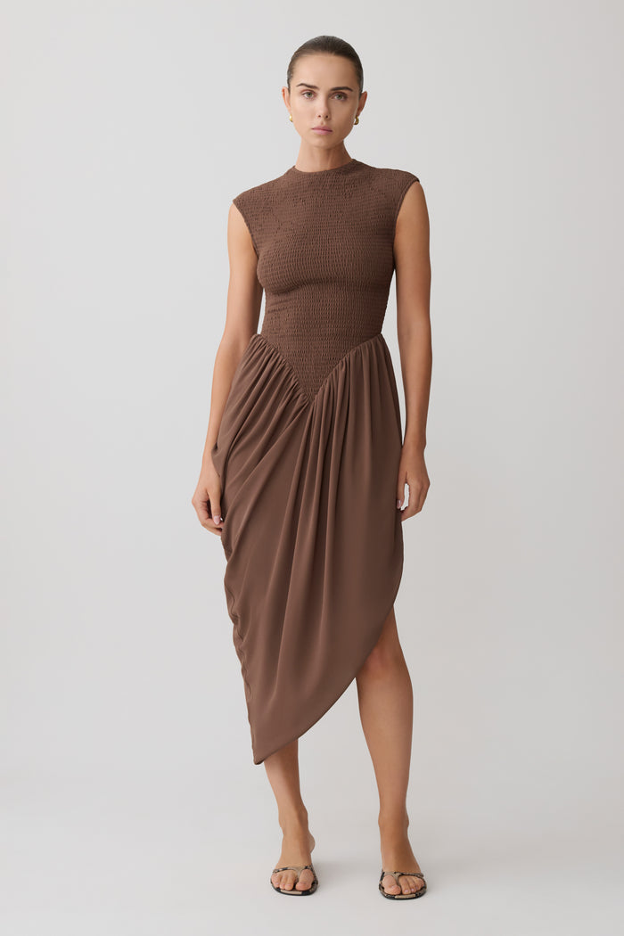 Woman wearing a brown shirred mini sleeveless dress.