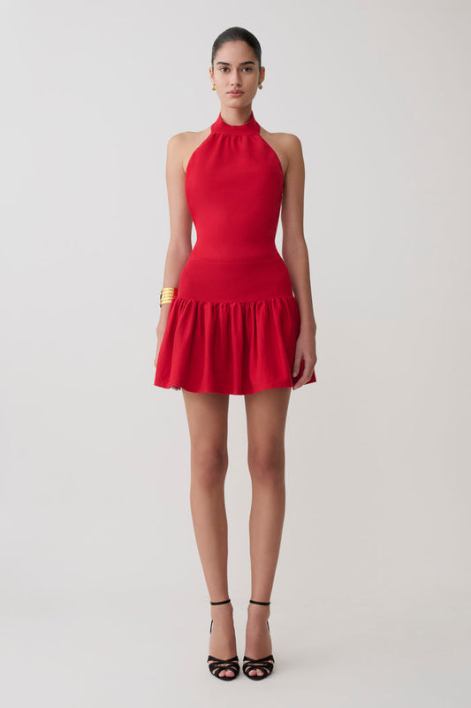 Red halter dress worn by a model on a light gray background