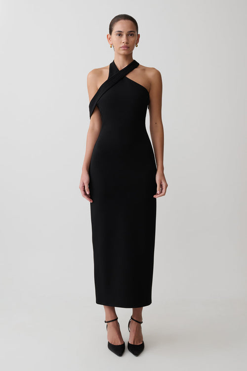 Woman wearing black crossover neck dress.