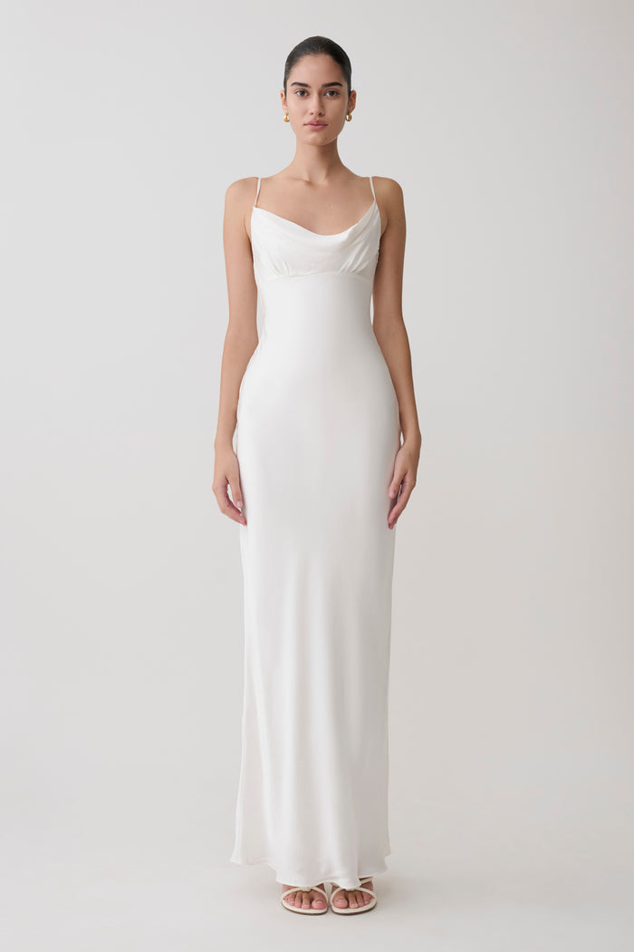 Woman wearing a white slip dress on a plain background