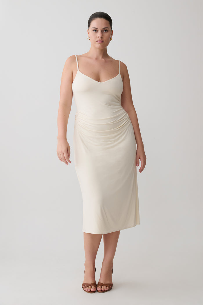 Woman wearing a white slip maxi dress.
